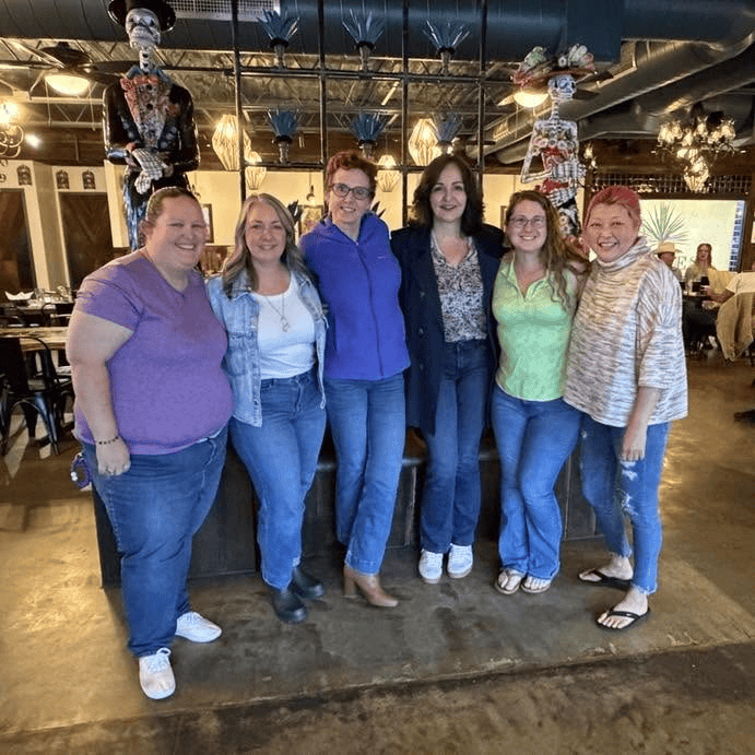 Group of 6 women shoulder to shoulder after dinner