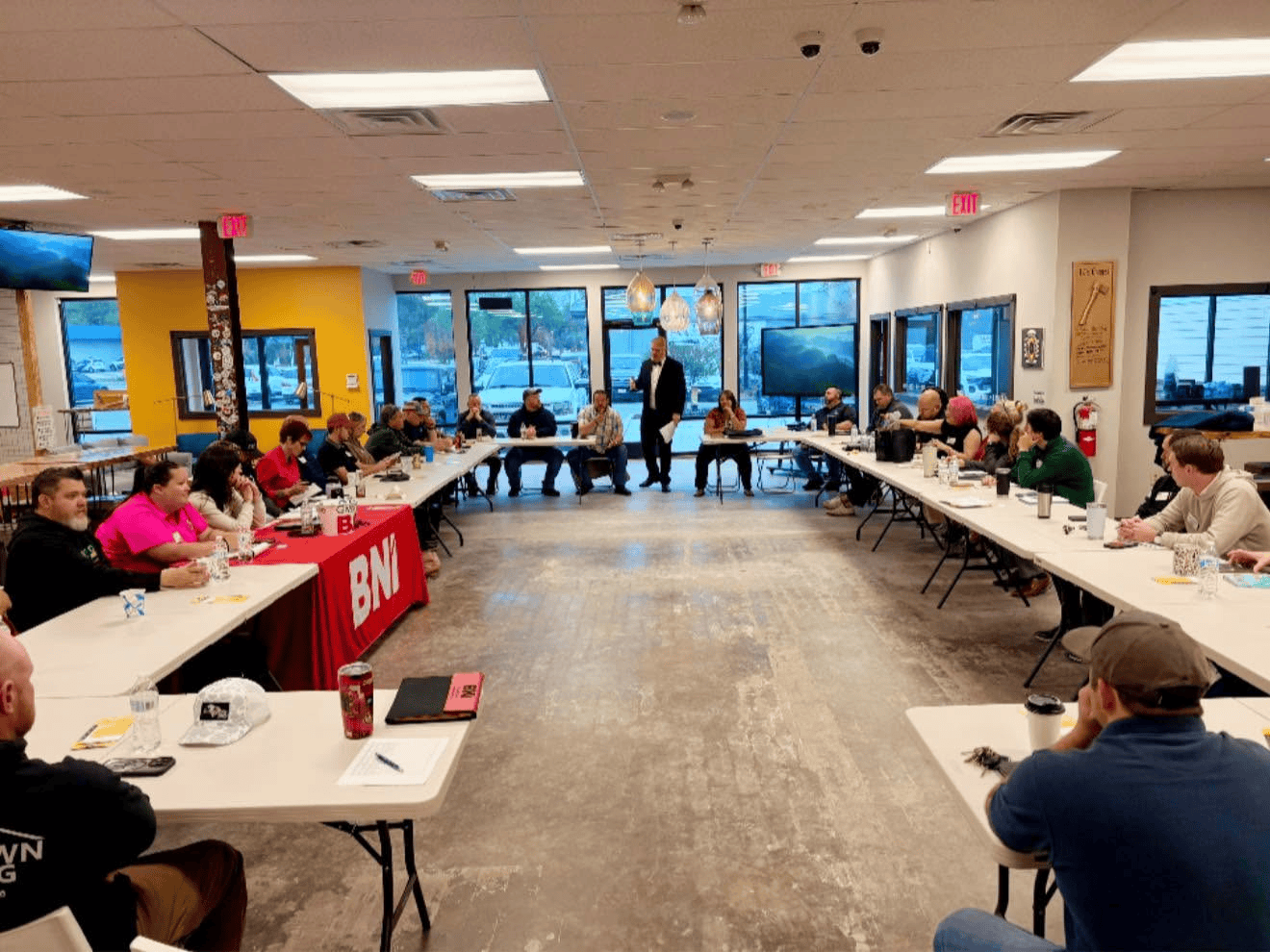 Tables in a square with around forty business owners and decision makers focused on a single topic